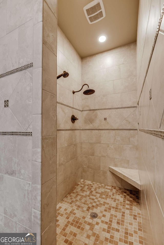 bathroom featuring recessed lighting, visible vents, and a tile shower