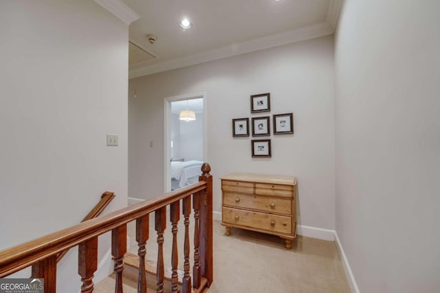 hall featuring crown molding, baseboards, an upstairs landing, and attic access