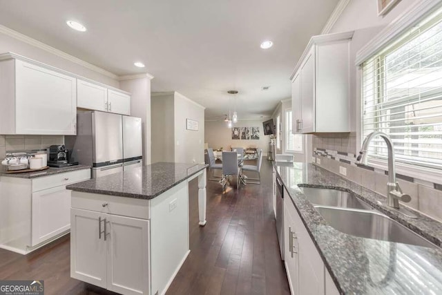 kitchen with a kitchen island, white cabinetry, appliances with stainless steel finishes, and sink