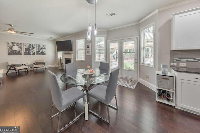 dining room featuring crown molding, dark wood-type flooring, and ceiling fan