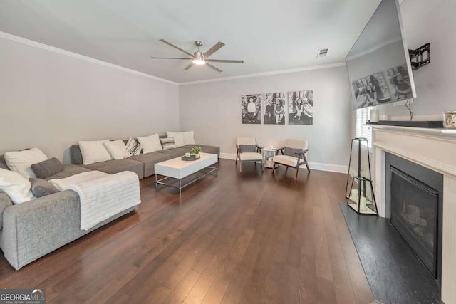 living room featuring dark wood-type flooring, ceiling fan, and ornamental molding