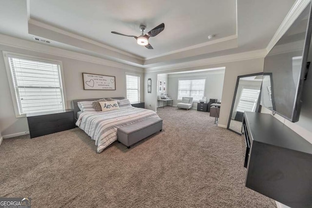 carpeted bedroom featuring ornamental molding, ceiling fan, and a tray ceiling