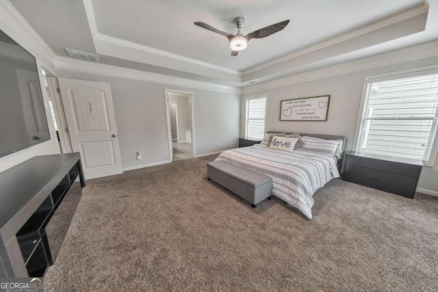 bedroom with ensuite bathroom, ornamental molding, a tray ceiling, carpet floors, and ceiling fan