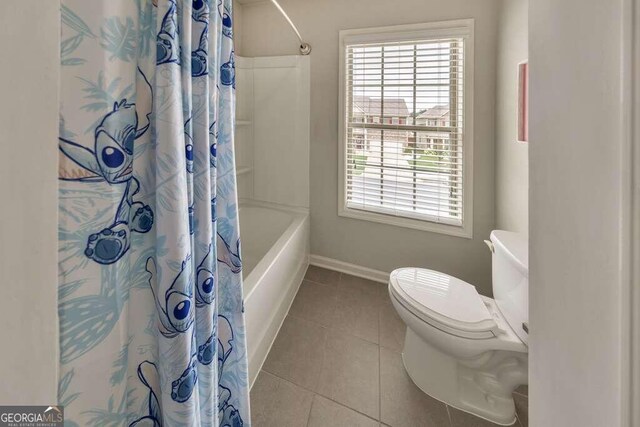 bathroom with tile patterned flooring, shower / bath combo, and toilet