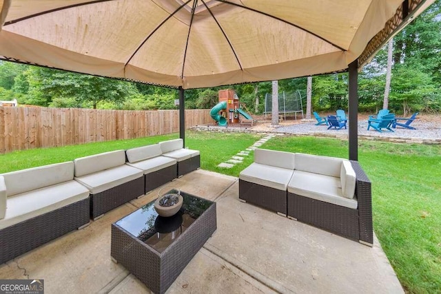 view of patio with a playground, an outdoor living space with a fire pit, and a trampoline