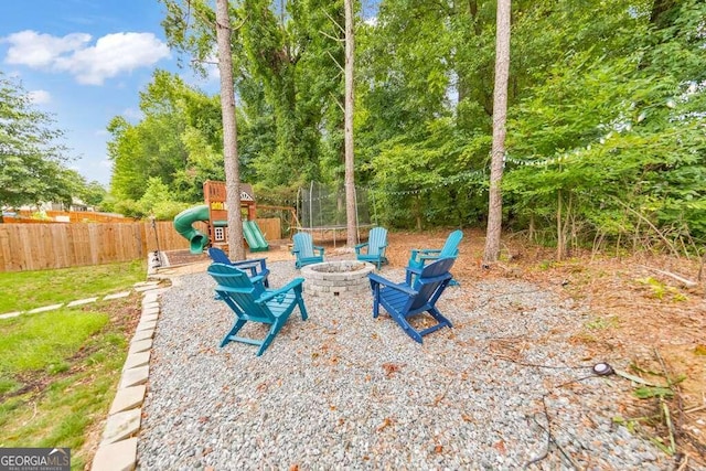 view of patio with a playground and an outdoor fire pit