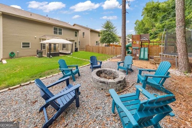 view of patio with a playground, a trampoline, and an outdoor fire pit