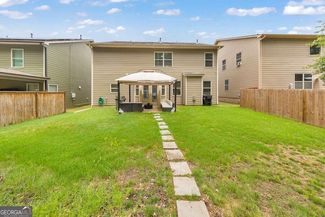 back of property featuring a gazebo and a lawn