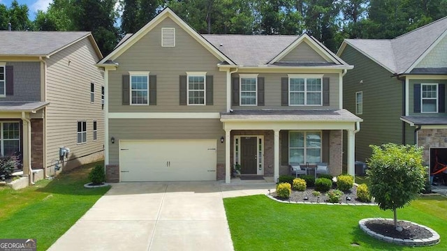 view of front of house featuring a garage, a front lawn, and a porch