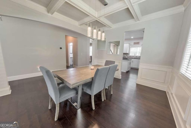 dining room with coffered ceiling, an inviting chandelier, crown molding, dark hardwood / wood-style flooring, and beamed ceiling