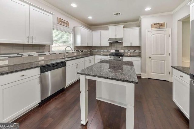 kitchen featuring a kitchen island, appliances with stainless steel finishes, sink, white cabinets, and dark stone counters