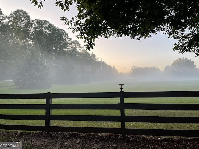 view of gate featuring a rural view and a lawn