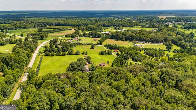 aerial view with view of golf course and a wooded view