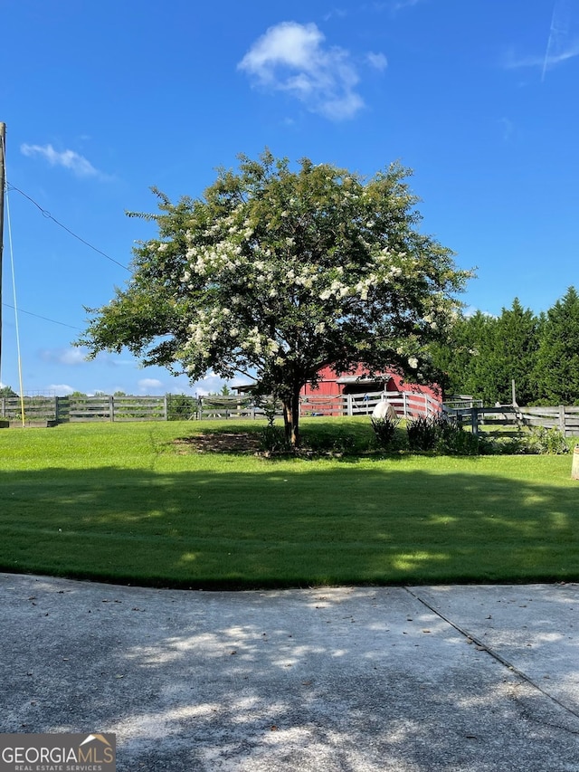 view of yard with a rural view and fence