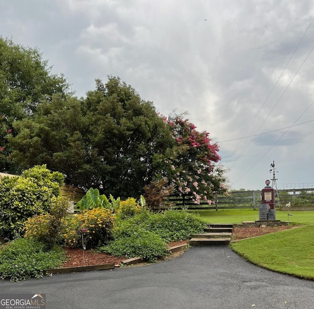 view of community with fence and a lawn