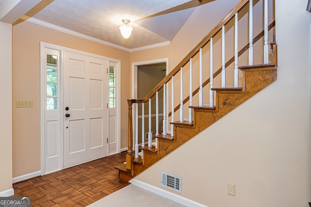 foyer featuring dark parquet flooring, a textured ceiling, and ornamental molding