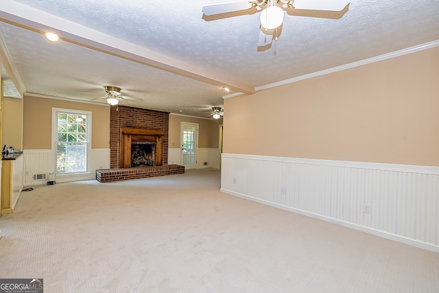 unfurnished living room with ceiling fan, a textured ceiling, light colored carpet, and a brick fireplace