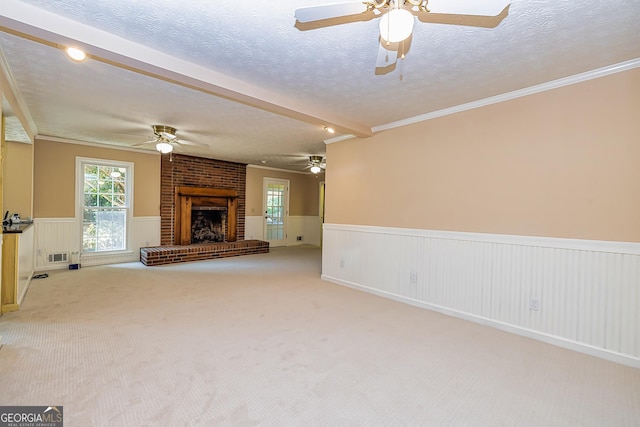 unfurnished living room with visible vents, a brick fireplace, light carpet, wainscoting, and a textured ceiling