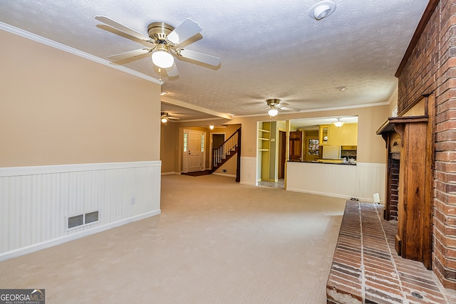 unfurnished living room with ceiling fan, ornamental molding, and light colored carpet