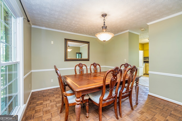 dining space with ornamental molding, a textured ceiling, and parquet flooring