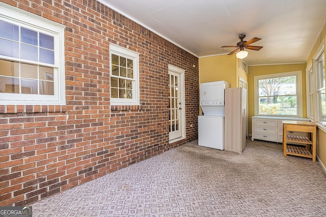 interior space featuring ceiling fan and stacked washer and dryer