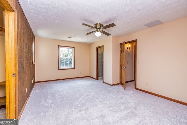 unfurnished bedroom with ceiling fan, a textured ceiling, and light carpet