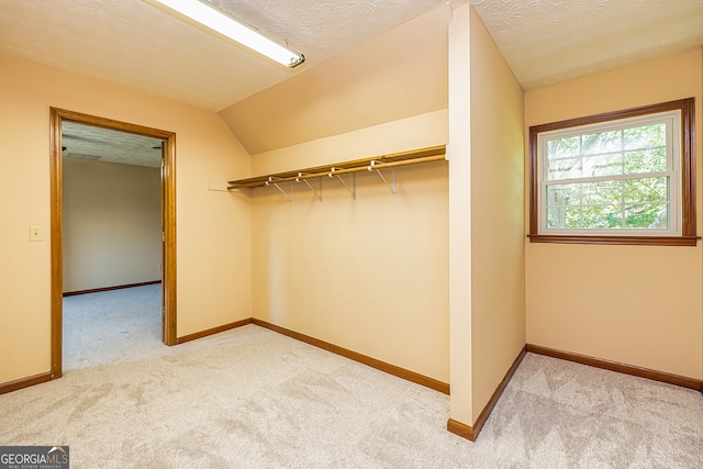 spacious closet with light carpet and lofted ceiling