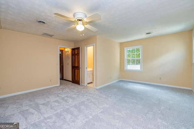 empty room with baseboards, visible vents, and light colored carpet