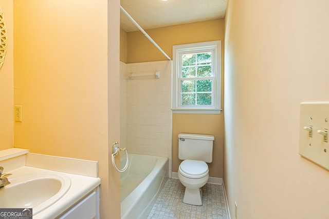 full bathroom with a textured ceiling, toilet, tiled shower / bath, tile patterned flooring, and vanity