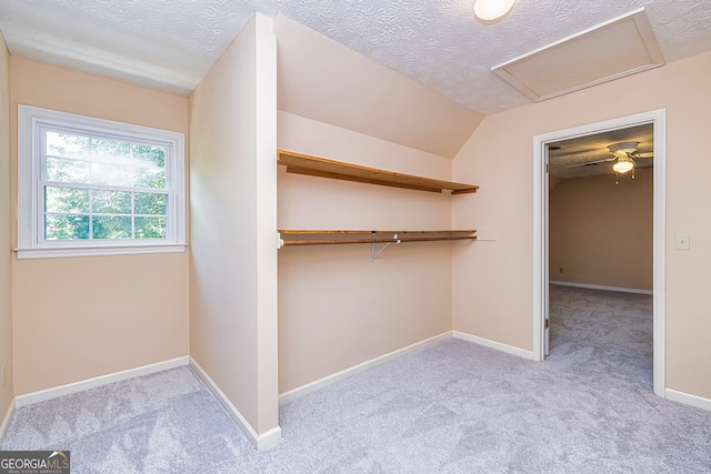 spacious closet featuring light carpet, lofted ceiling, and ceiling fan