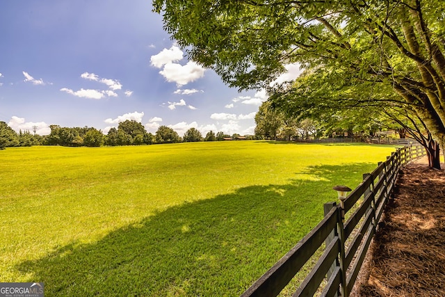 view of yard featuring fence and a rural view