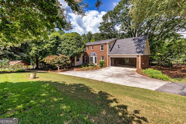 view of front facade with a front yard, concrete driveway, and brick siding