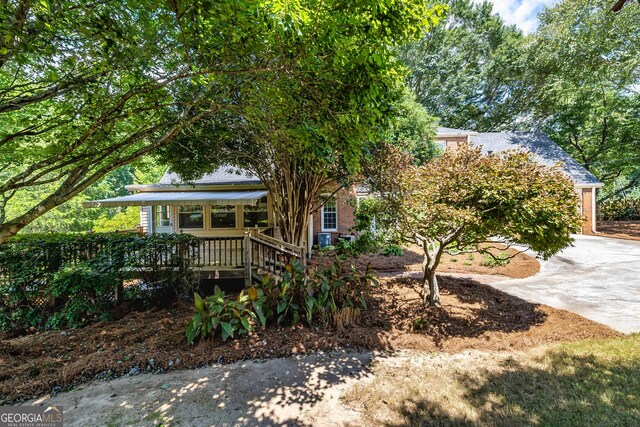 obstructed view of property featuring driveway and brick siding