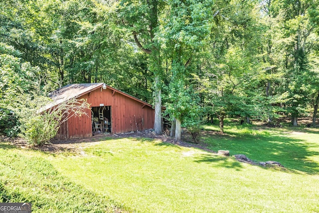 view of yard with an outbuilding, an outdoor structure, and a view of trees