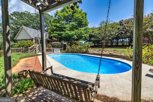 view of swimming pool featuring a wooden deck and a patio