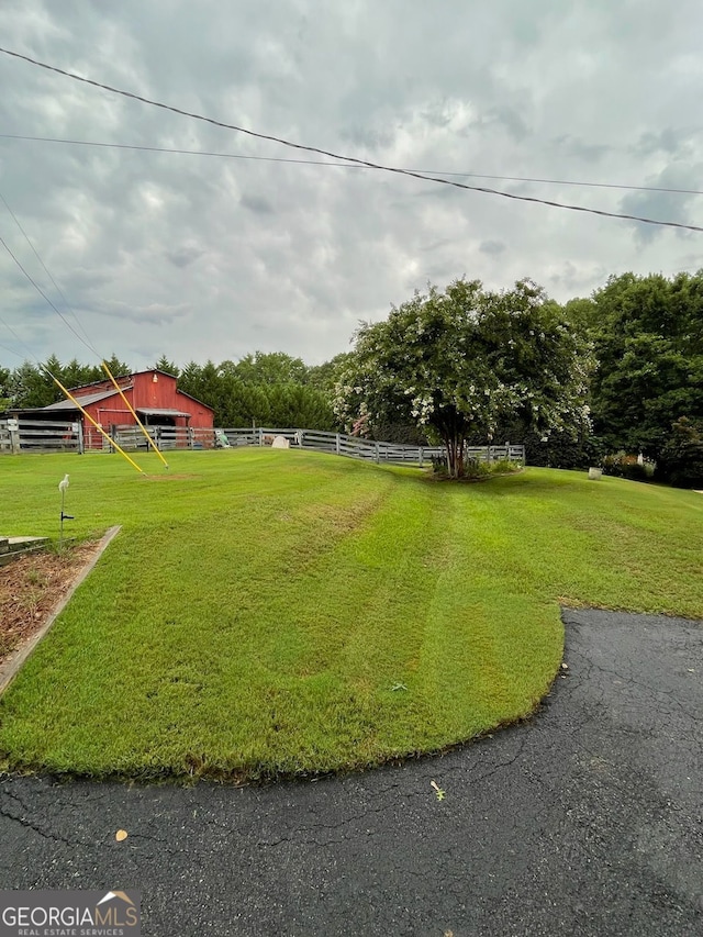 view of yard featuring an outbuilding and fence