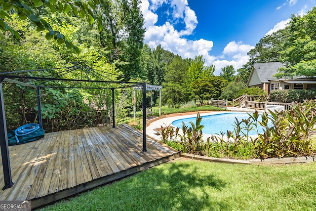 view of pool featuring a yard and a wooden deck