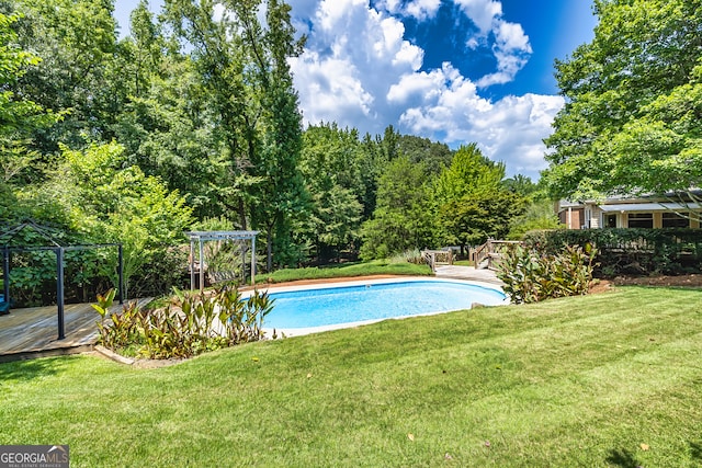 view of pool with a deck and a yard