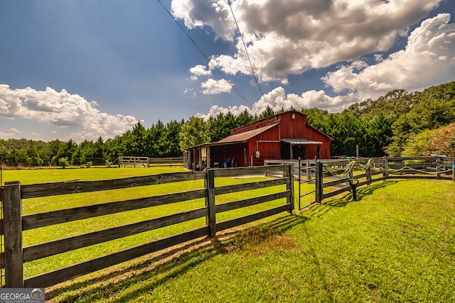 view of horse barn with a rural view, a yard, and an outbuilding