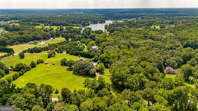 aerial view with golf course view, a water view, and a wooded view