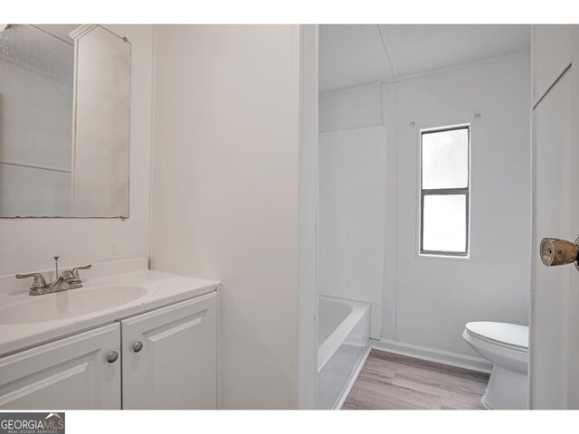 full bathroom featuring shower / bathtub combination, vanity, hardwood / wood-style floors, and toilet