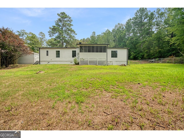 back of house with a sunroom and a yard