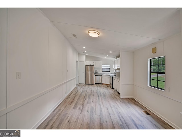 interior space featuring light hardwood / wood-style flooring and vaulted ceiling