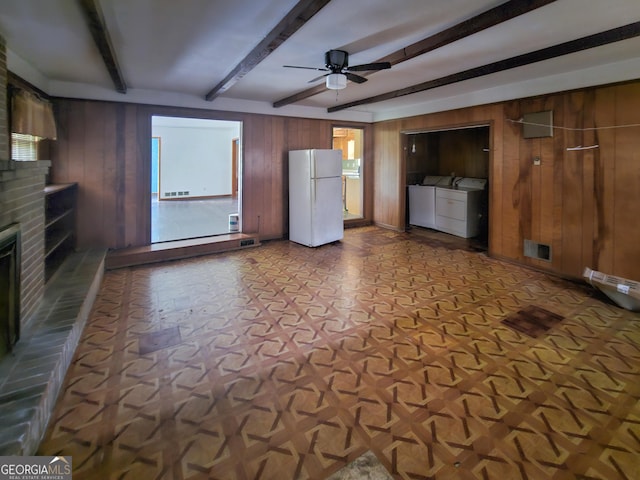 8347 Hilltop Rd, Jonesboro, GA 30236 - unfurnished living room featuring ceiling fan, beam ceiling, wooden walls, washing machine and clothes dryer, and a brick fireplace