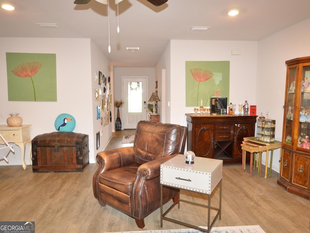 living room featuring light wood-type flooring and ceiling fan