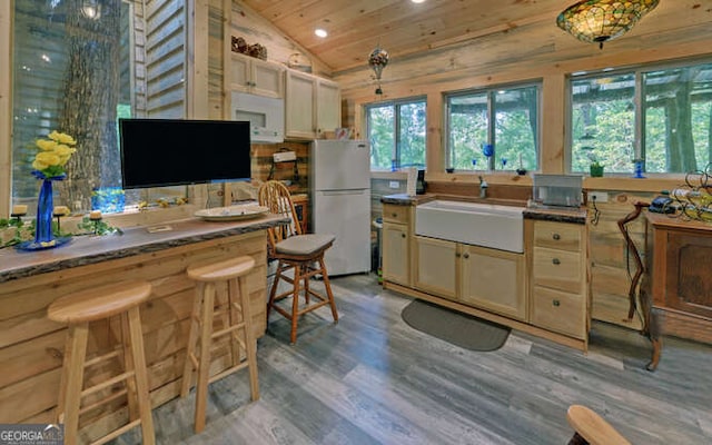 kitchen with plenty of natural light, white refrigerator, light hardwood / wood-style flooring, and vaulted ceiling