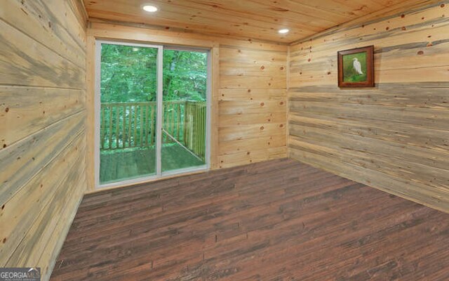 empty room with wooden ceiling, hardwood / wood-style flooring, and wooden walls