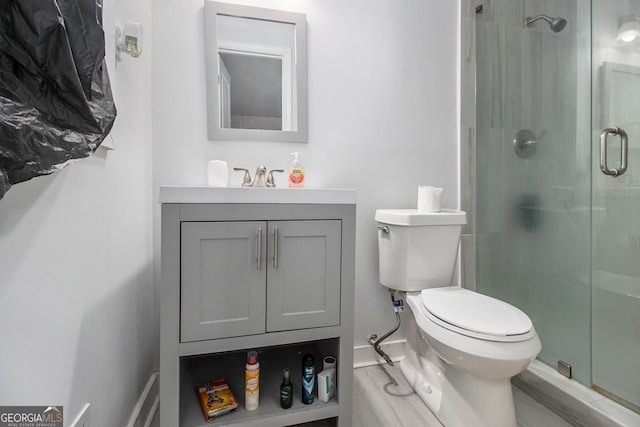 bathroom with vanity, toilet, and an enclosed shower