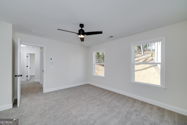 spare room with ceiling fan and light carpet