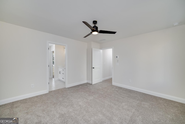 unfurnished bedroom featuring ceiling fan, light carpet, and connected bathroom